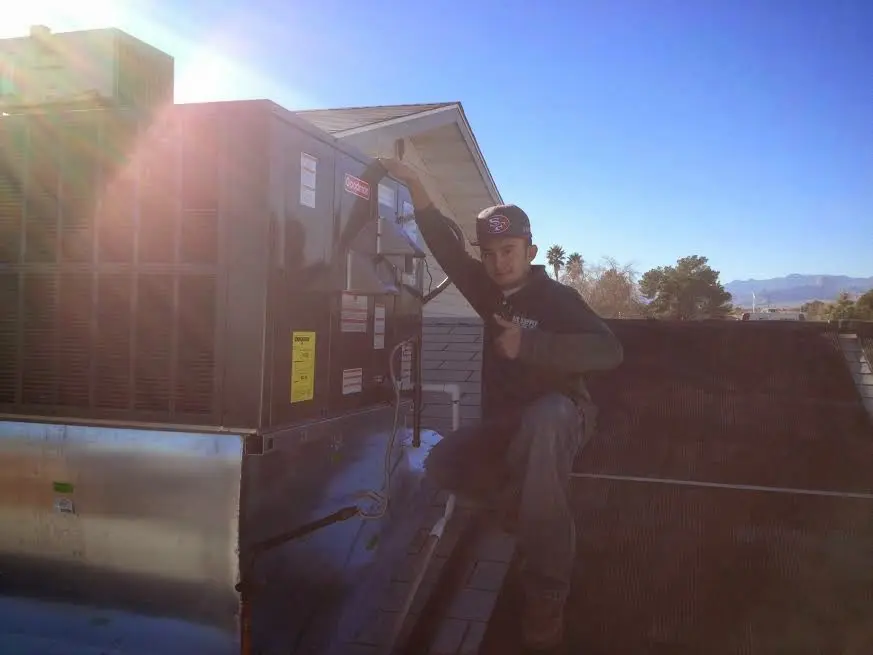 HVAC technician performing AC Tune-Up on a rooftop unit in Forest Park