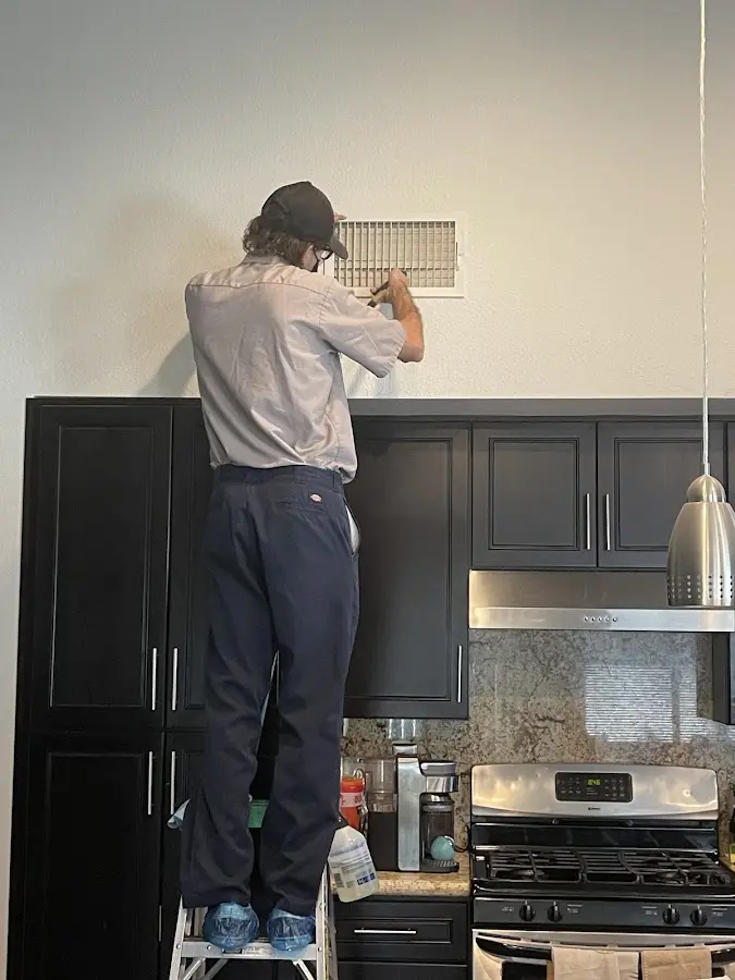 Technician inspecting an air vent during HVAC service in Forest Park